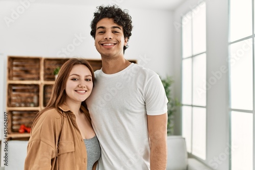 Young couple smiling happy and hugging standing at home.