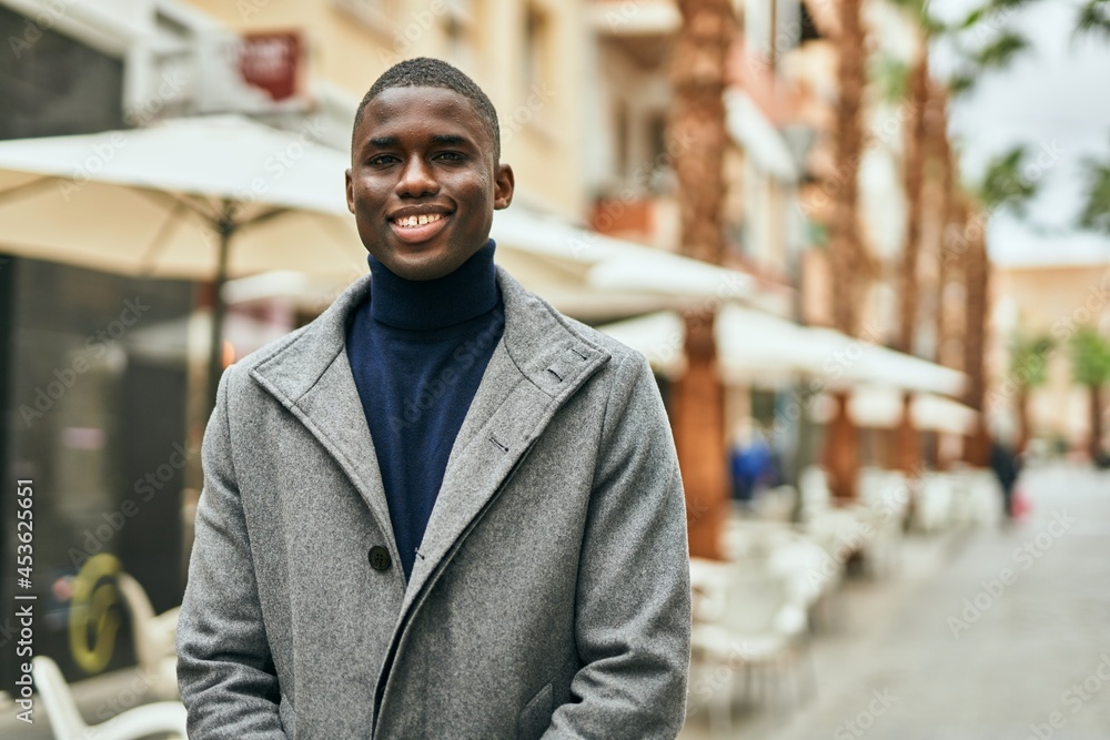 Obraz premium Young african american man smiling happy standing at the city
