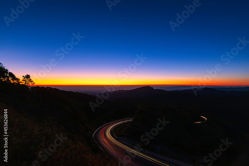 Sunrise scence of car light trail to the top with curve of road at Doi Inthanon National park in Chiang Mai Province  Thailand