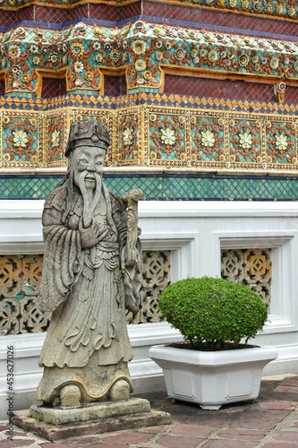 Political Nobleman is smiling-face rock statues beside a gate in Wat Pho also spelled Wat Po, is a Buddhist temple in Bangkok, Thailand.