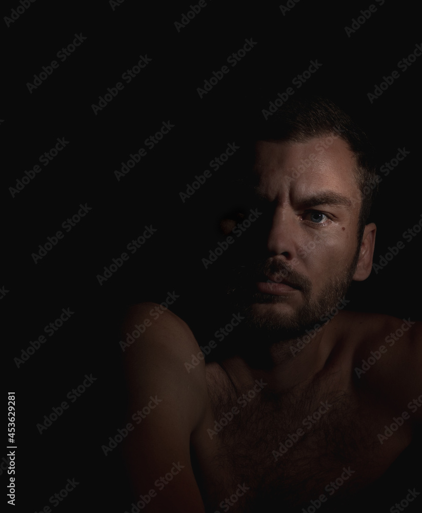 Art portrait of middle-aged man, full face photography in the dark. Russian ethnicity person, 34 years old.