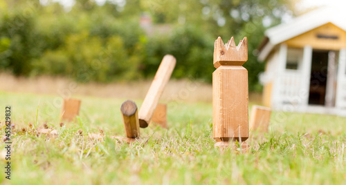 Wikingerschach (Kubb) aus Holz in Garten aufgestellt. Wooden Kubb sticks in garden. photo