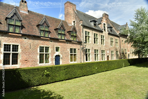 L'une des pelouses carrées garnie d'arbres et de haie au Grand Béguinage de Louvain (Leuven)