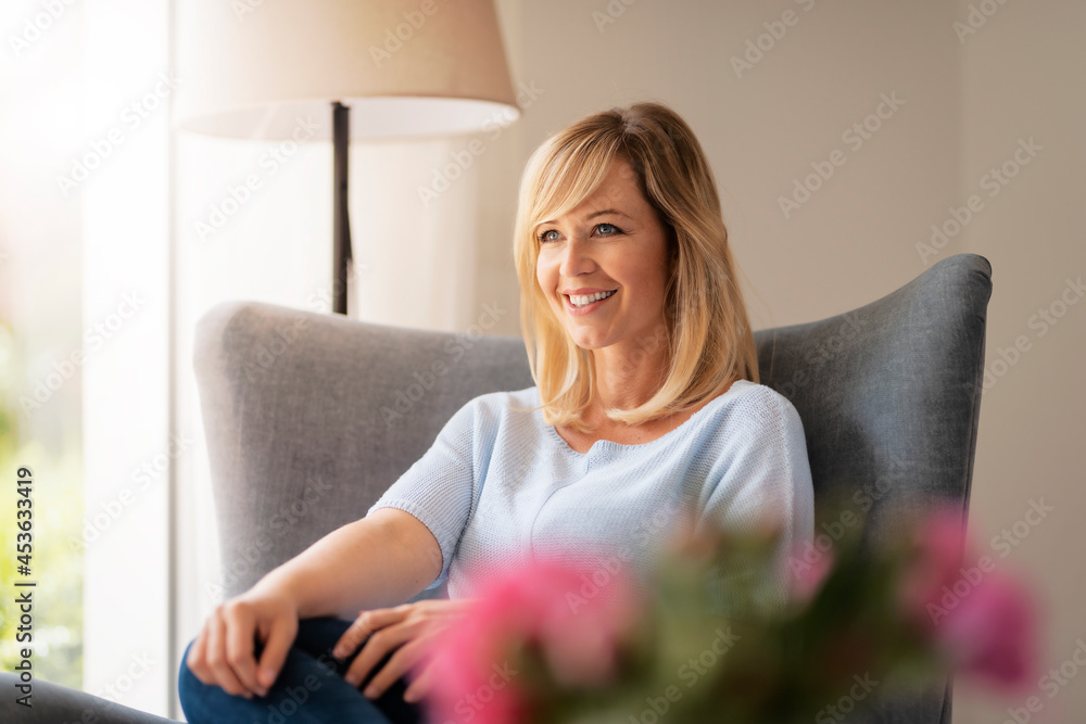 Smiling blond haired woman relaxing at home Smiling blond haired woman relaxing at home