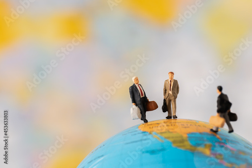 Miniature people Group Business man mini figures standing thinking on Global ball map background with copy space using as thinking business plan and how to solve problem Strategy Planning concepts