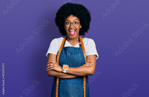Photos Young african american woman dressmaker designer wearing atelier apron celebrating crazy and amazed for success with open eyes screaming excited