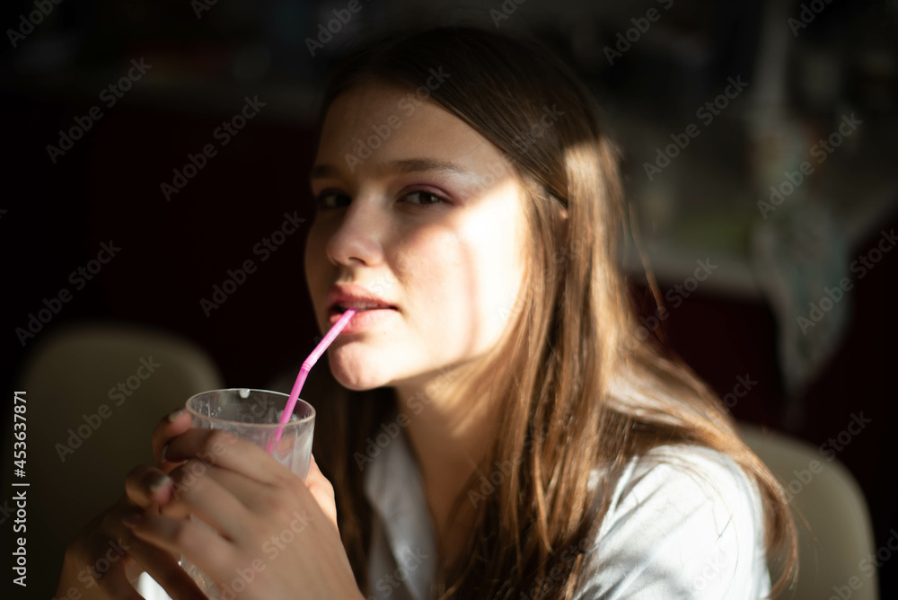 Fashion lifestyle image of pretty teenage young woman sitting in kitchen. Natural beauty. Fashion lifestyle image of pretty teenage young woman sitting in kitchen. Natural beauty.