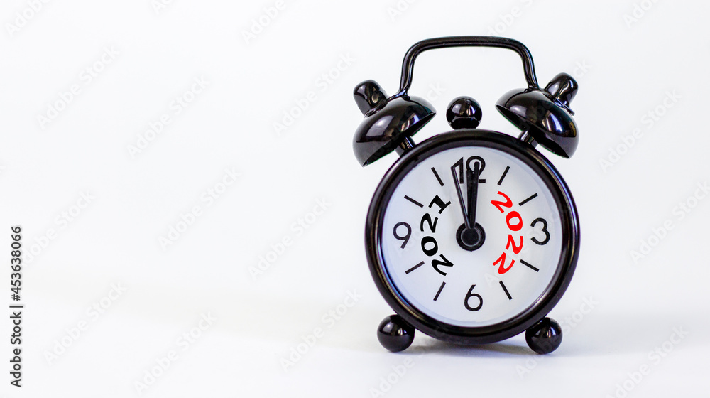 2022 happy new year symbol. Beautiful black alarm clock with numbers 2021 and 2022. Beautiful white background. Copy space. Business and 2021 happy new year concept. 2022 happy new year symbol. Beautiful black alarm clock with numbers 2021 and 2022. Beautiful white background. Copy space. Business and 2021 happy new year concept.