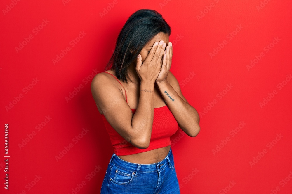 Young african american girl wearing casual style with sleeveless shirt with sad expression covering face with hands while crying. depression concept. Young african american girl wearing casual style with sleeveless shirt with sad expression covering face with hands while crying. depression concept.