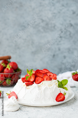 Pavlova cake with meringue and fresh strawberries on a light background, selective focus