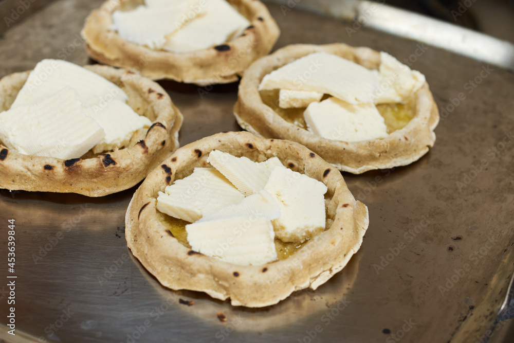 Sopes with cheese cooking on a comal. Mexican gastronomy concept. Sopes with cheese cooking on a comal. Mexican gastronomy concept.