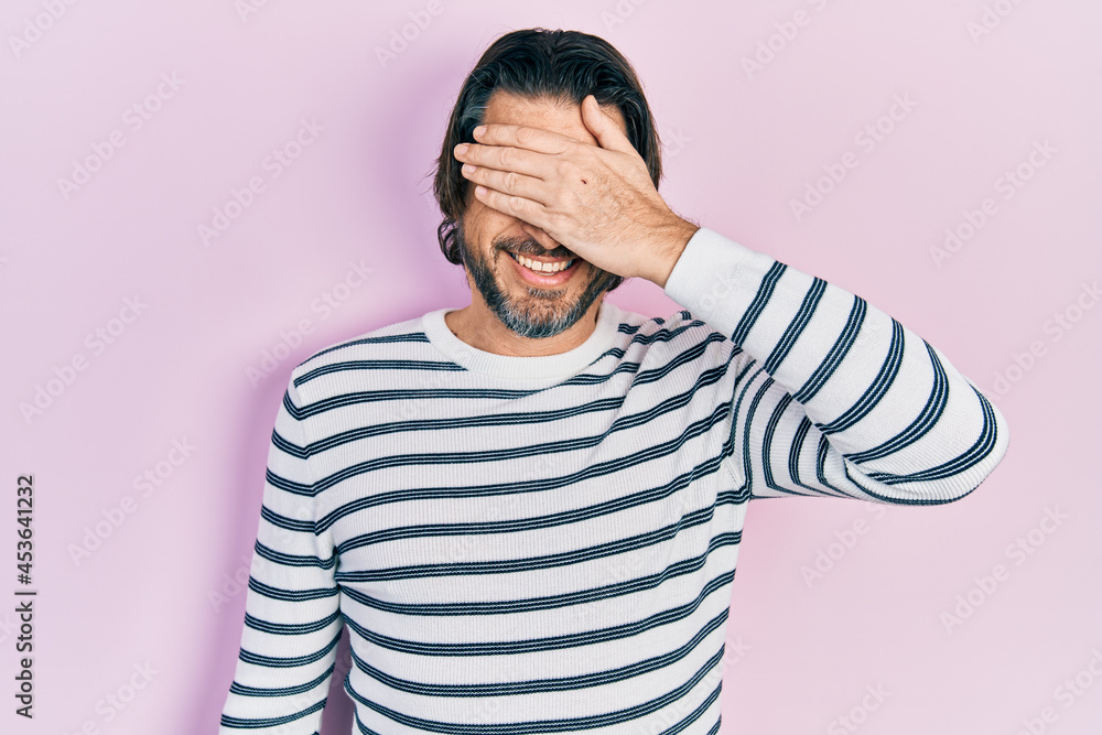 Middle age caucasian man wearing casual clothes smiling and laughing with hand on face covering eyes for surprise. blind concept. Middle age caucasian man wearing casual clothes smiling and laughing with hand on face covering eyes for surprise. blind concept.