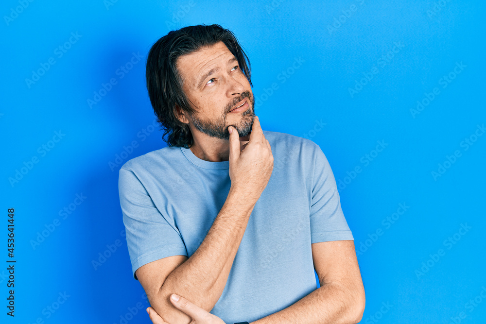 Middle age caucasian man wearing casual clothes with hand on chin thinking about question, pensive expression. smiling with thoughtful face. doubt concept.