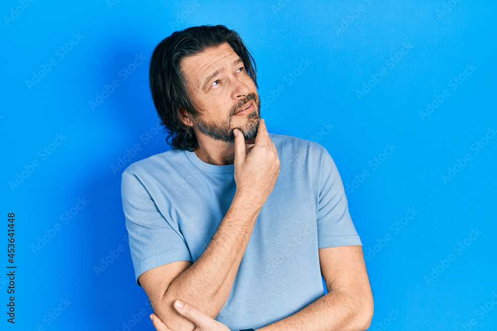 Middle age caucasian man wearing casual clothes with hand on chin thinking about question, pensive expression. smiling with thoughtful face. doubt concept. Middle age caucasian man wearing casual clothes with hand on chin thinking about question, pensive expression. smiling with thoughtful face. doubt concept.