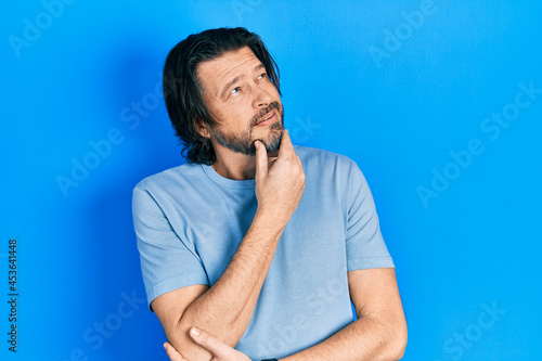 Middle age caucasian man wearing casual clothes with hand on chin thinking about question  pensive expression. smiling with thoughtful face. doubt concept.