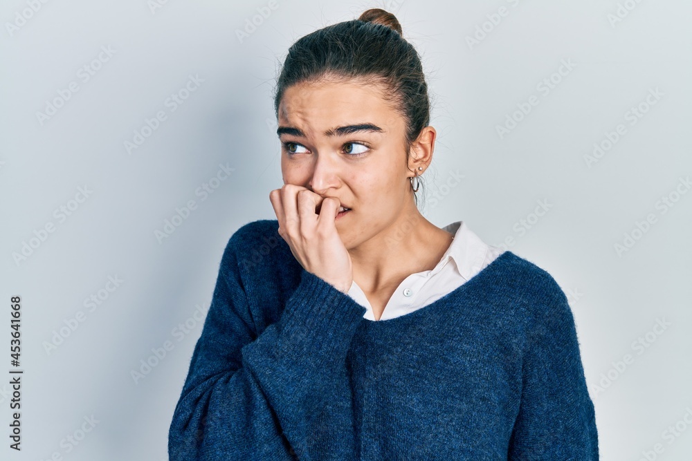 Young caucasian girl wearing casual clothes looking stressed and nervous with hands on mouth biting nails. anxiety problem. Young caucasian girl wearing casual clothes looking stressed and nervous with hands on mouth biting nails. anxiety problem.