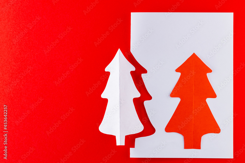 Paper Christmas tree on a red background. White paper christmas tree. Christmas minimal concept
