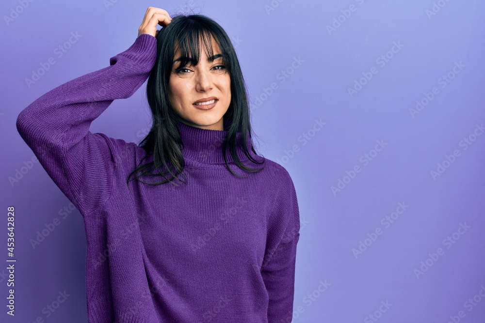 Young brunette woman with bangs wearing turtleneck sweater confuse and wonder about question. uncertain with doubt, thinking with hand on head. pensive concept. Young brunette woman with bangs wearing turtleneck sweater confuse and wonder about question. uncertain with doubt, thinking with hand on head. pensive concept.