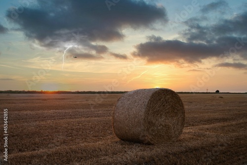 hay lies in a field at sunset