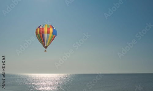 hot air balloon flies over the sea
