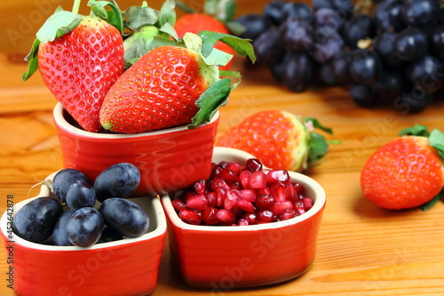 healthy fresh strawberries  grapes and pomegranate seeds on kitchen worktop