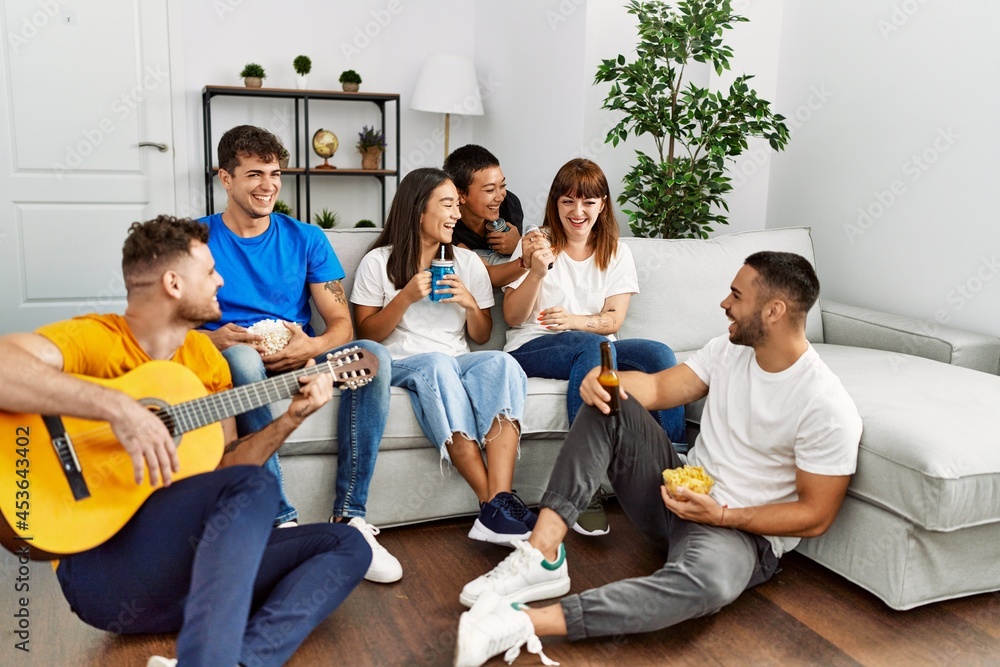 Group of young friends on party smiling happy and playing classical guitar at home. Group of young friends on party smiling happy and playing classical guitar at home.