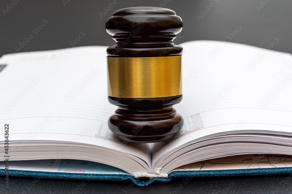 Judge's gavel on opened notepad. Close up. Judge's gavel on opened notepad. Close up.