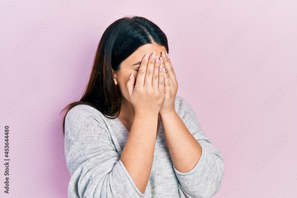 Young hispanic woman wearing casual clothes with sad expression covering face with hands while crying. depression concept. Young hispanic woman wearing casual clothes with sad expression covering face with hands while crying. depression concept.