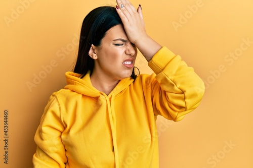 Beautiful brunette woman wearing casual sweatshirt surprised with hand on head for mistake, remember error. forgot, bad memory concept. © Krakenimages.com
