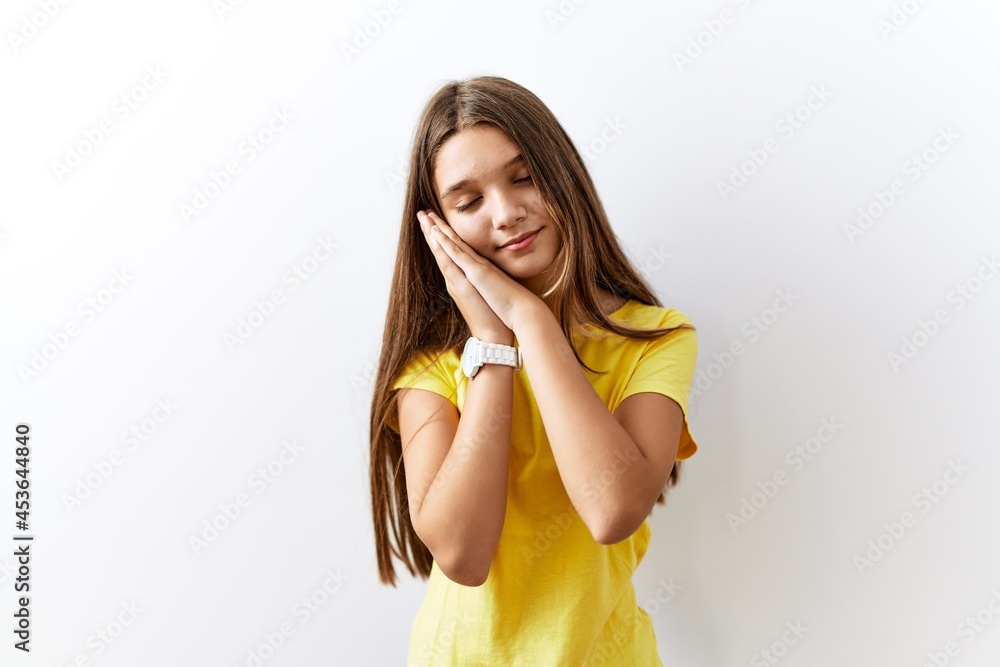 Young brunette teenager standing together over isolated background sleeping tired dreaming and posing with hands together while smiling with closed eyes. Young brunette teenager standing together over isolated background sleeping tired dreaming and posing with hands together while smiling with closed eyes.