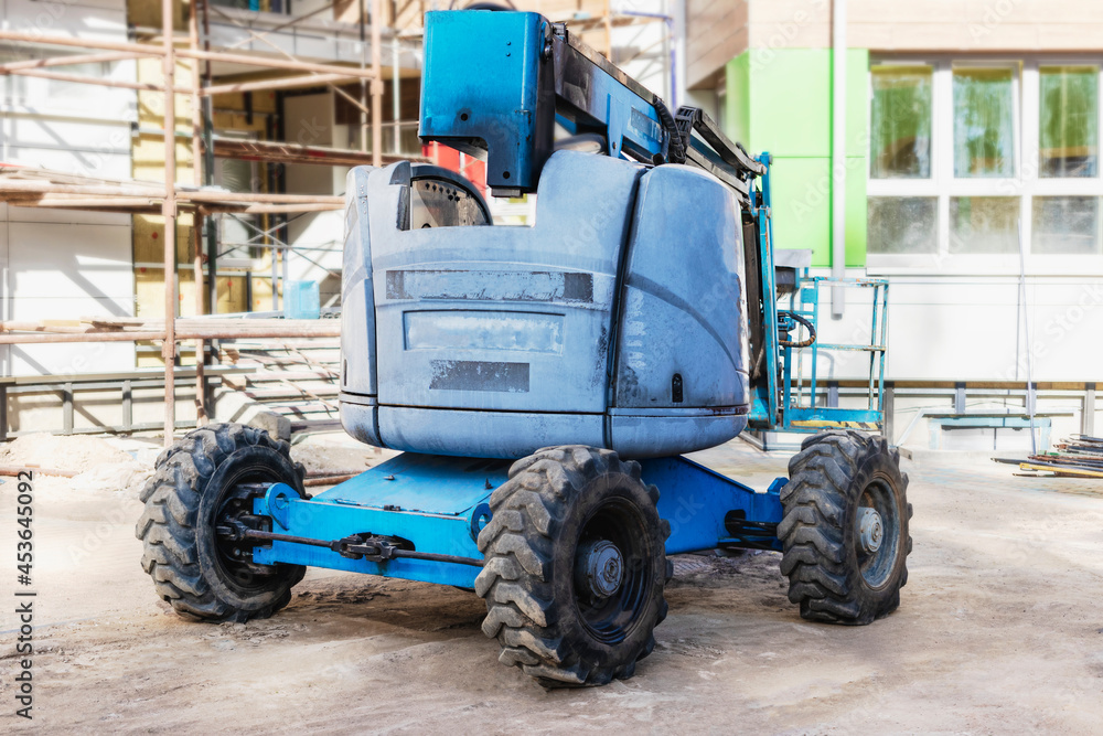 Man's work is at a height. Self-propelled construction mechanism for lifting workers to a height on a construction site. Safe work at the top. Man's work is at a height. Self-propelled construction mechanism for lifting workers to a height on a construction site. Safe work at the top.