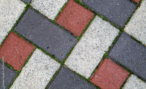 Colored background and texture of new paving slabs. The texture of the paved tiles is red and gray. Cement brick squared stone floor background. Concrete paving slabs.