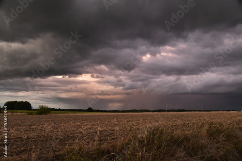 Lumière du soleil couchant sur les nuages d'orages au dessus des champs au bourg de Champagne au Périgord Vert