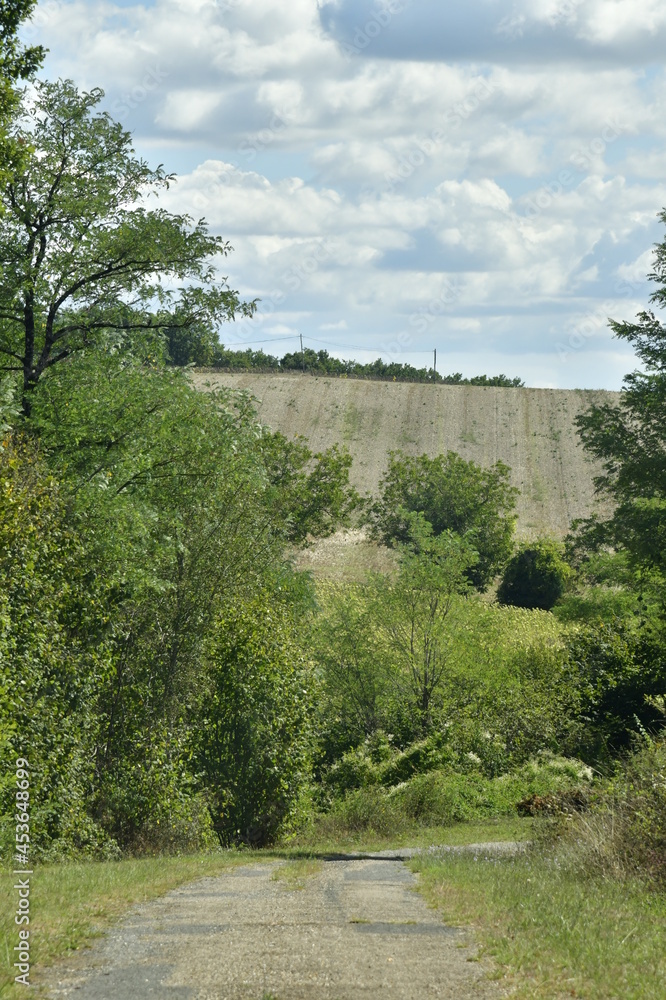 Route rocailleuse de campagne entre végétation sauvage sur les collines dominant le bourg de Champagne au Périgord Vert 