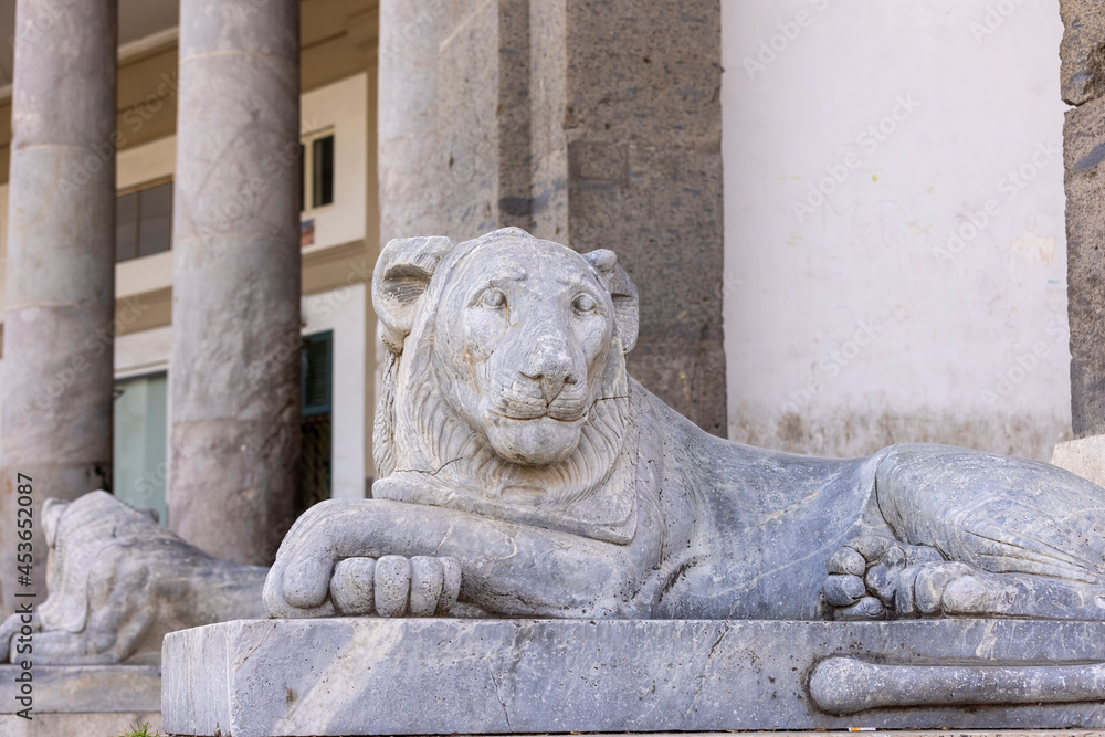 Statue of lion in front of Basilica of San Francesco di Paola, 19th century neoclassical church situated on Piazza del Plebiscito, Naples, Italy