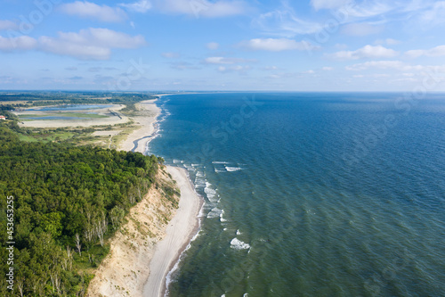 Baltic coastline with green summer forest and the sea. Aerial view from drone