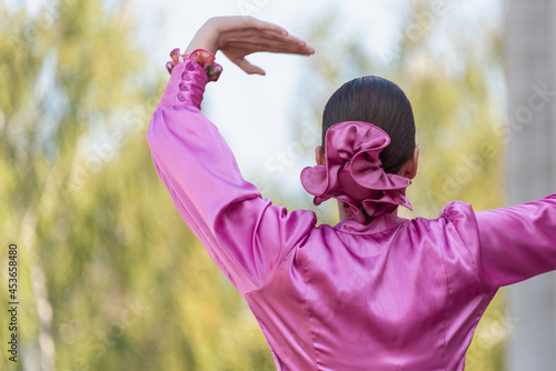 The girl is dancing with her hands up.
