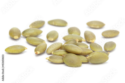 Micro close-up and details of Organic roasted green pumpkin seed (Cucurbita pepo)  isolated over white background.
