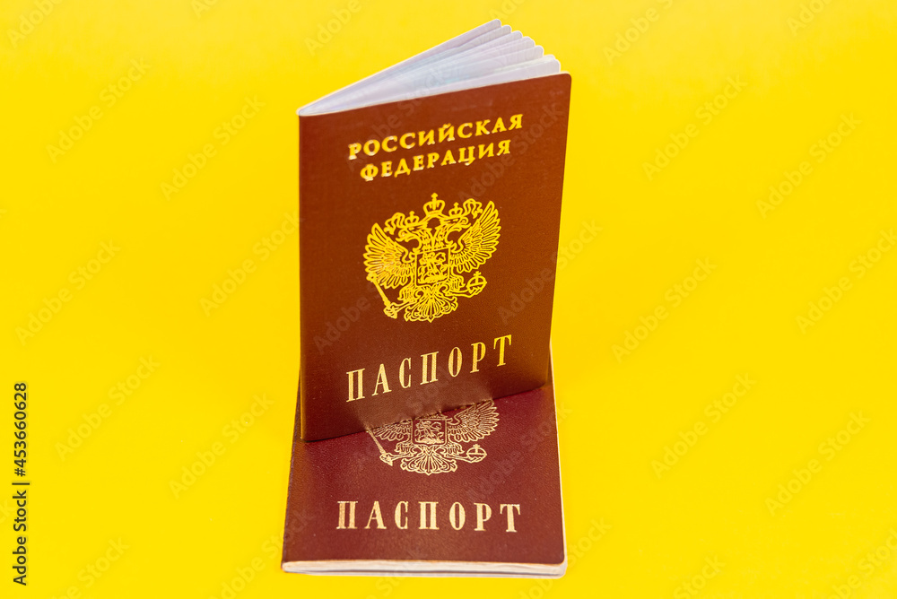 Russian passport stands in a semi-expanded form on another passport. Russian passport stands in a semi-expanded form on another passport.