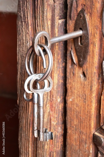 set of keys and antique plate on a wooden door from the early 20th century
