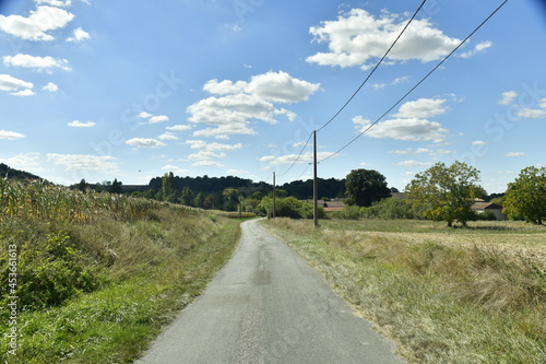 Petite route secondaire de campagne traversant prairies et champs au bourg de Champagne-et-Fontaine au Périgord Vert 