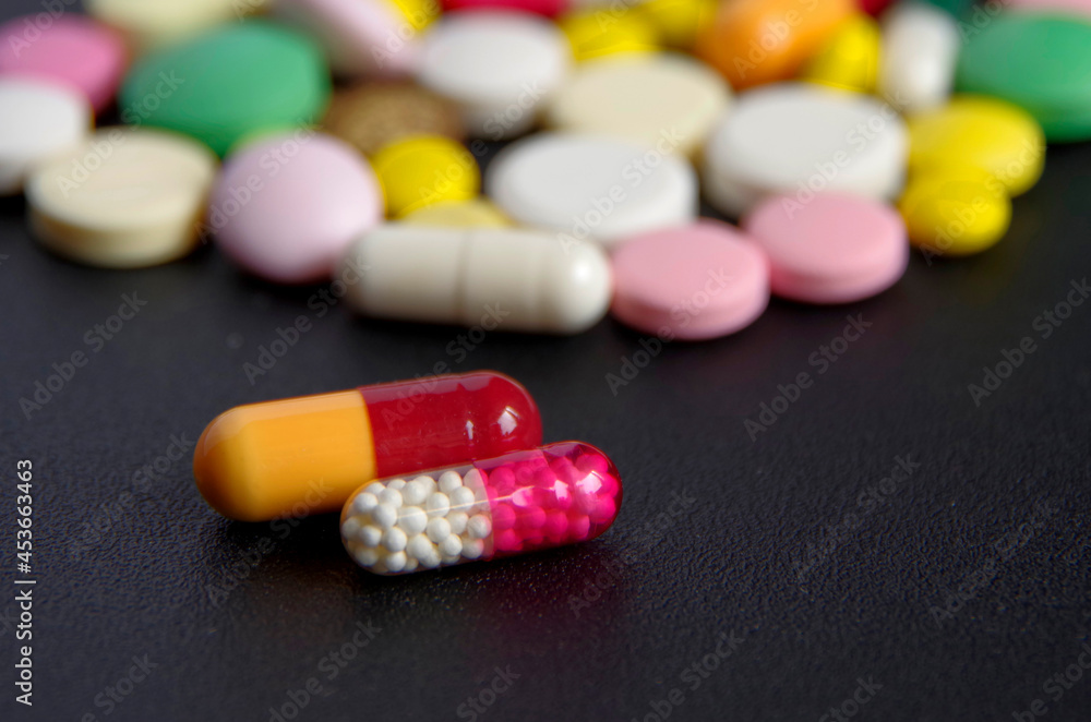 Medicines in the form of capsules and tablets on a dark background. Medicines in the form of capsules and tablets on a dark background.