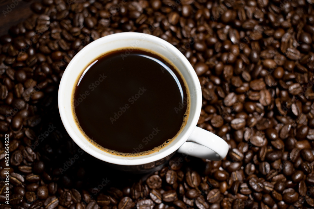 Coffee cup top view on roasted coffee beans background Coffee cup top view on roasted coffee beans background