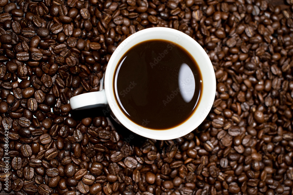 Coffee cup top view on roasted coffee beans background Coffee cup top view on roasted coffee beans background
