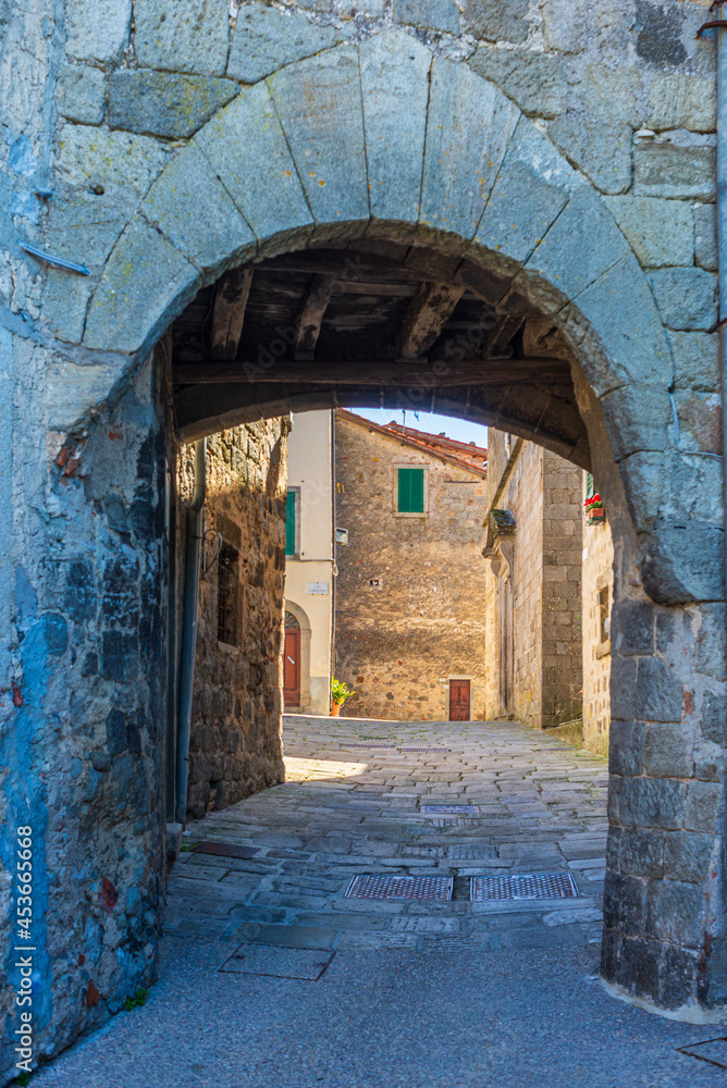 Italian medieval village details, historical stone arch, ancient gate, old city stone buildings architecture. Santa Fiora, Tuscany, Italy.