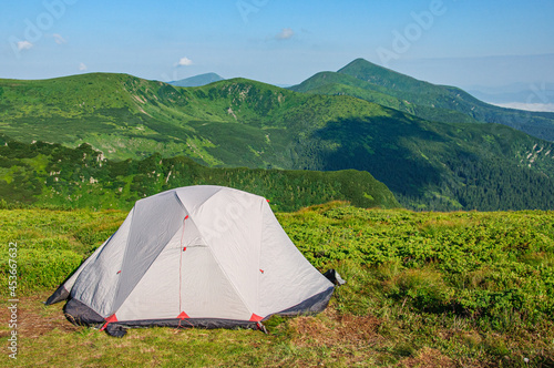 A gray tent stands in a clearing in the Carpathians overlooking Hoverla - the highest mountain of the Ukrainian Carpathians