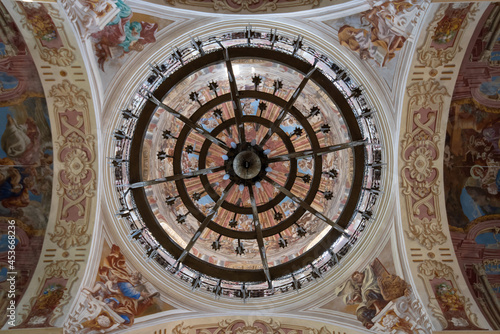 Belarus  Nesvizh - June 26  2021. Catholic church of Corpus Christi in Nesvizh. Painted vault ceiling with a chandelier. Bottom view.