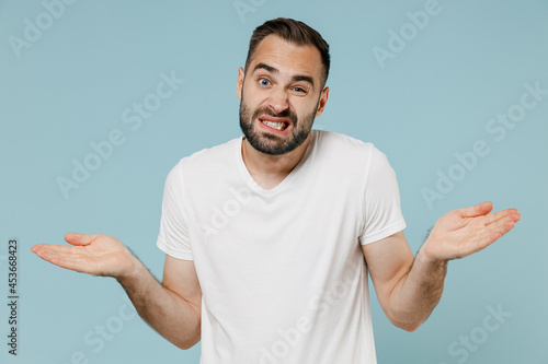 Photos Young man in white t-shirt hrugging shoulders looking puzzled, have no idea, not