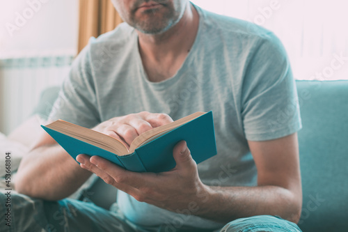 Photos Man reading book at home, enjoying a good read alone