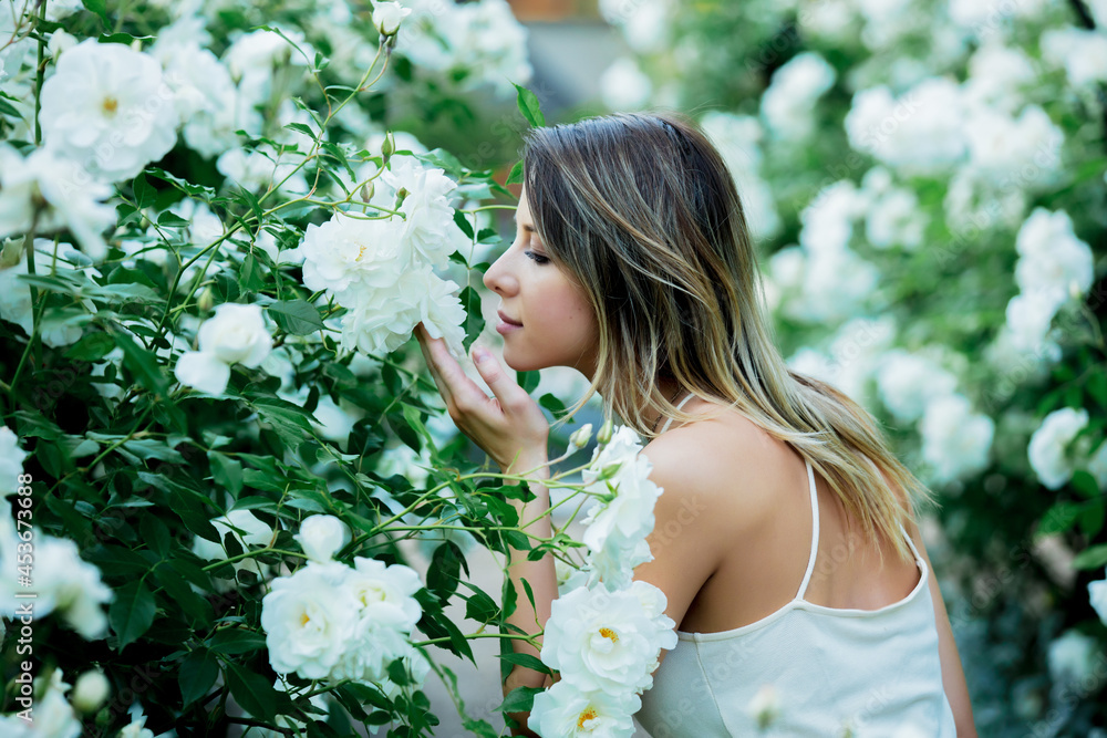 Fototapeta premium style woman near white roses in a grarden in spring time
